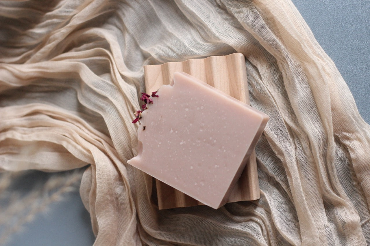 Pink soap bar on a beige fabric background
